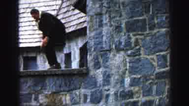 Lake Tahoe California (1969): Man Climbing Wall Attached To House With Blue Bricks