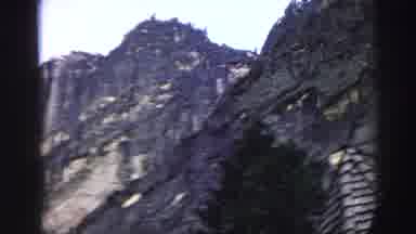 Lake Tahoe California (1969): A Very Tall Mountainside With Dark Foliage On A