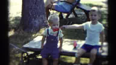 Disneyland California (1959): Small Boy Feeds Little Brother Ice Pop As Parents