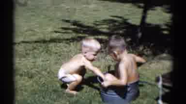 Disneyland California (1959): Two Boys Playing In Bucket Of Water On Sunny Day