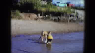 Disneyland California (1959): Two Small Kids In Yellow Floats Play In The Ocean