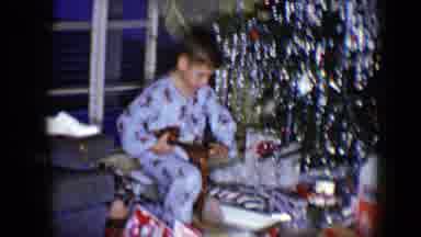 Disneyland California (1959): Little Boy Wearing Pajamas Holding Up A Gift He