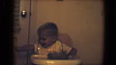 Disneyland California (1959): A Toddler Boy Sits In His Highchair Smiling And