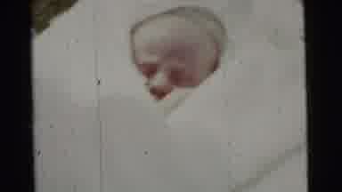 Gary Indiana USA (1961): A Small Baby Sits Very Comfortably Nestled In A White