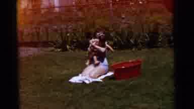 Gary Indiana USA (1961): Woman Sitting And Child Standing On Grass On A Sunny Day