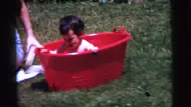 Gary Indiana USA (1961): Baby Takes A Bath In A Red Bucket While Her Mother