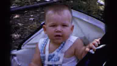Gary Indiana USA (1961): Baby Boy Sitting Up In Stroller Outside With Toy In Hand