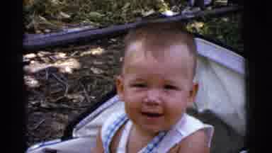 Gary Indiana USA (1961): Little Smiling Baby Laughs On His Stroller While Looking