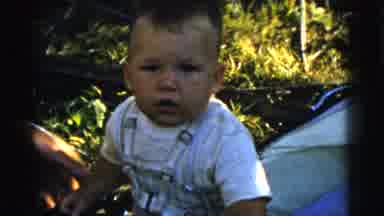 Gary Indiana USA (1961): A Baby Sitting Is Garden Is Smiling While Catching A Red