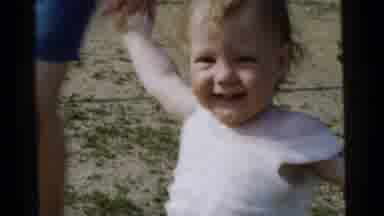 Gary Indiana USA (1961): A Smiling Child Walking While Holding A Grown Ups Hands