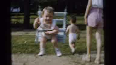 Gary Indiana USA (1961): A Young Child Who Is Wearing White Is Swinging On An