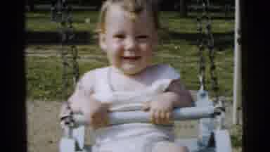 Gary Indiana USA (1961): A Baby Holding Onto Swing Swinging Outdoors On A Swing