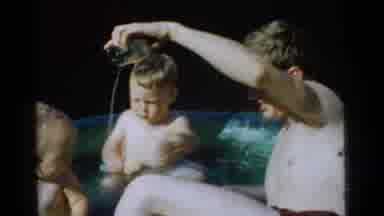 Gary Indiana USA (1961): Man Pouring Water From A Cup In A Baby Pool With Two