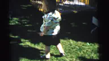 Gary Indiana USA (1961): Male Toddler Walks Across Grass As Woman Follows Him