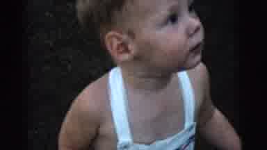 Gary Indiana USA (1961): Baby Dressed In White Overalls Playing Outside With