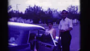 Clarkdale Arizona (1966): A Man With Women Is Standing Near Car And Smoking