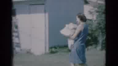 Clarkdale Arizona (1966): Woman Walks Across Yard With Bundle Of Clothes Man