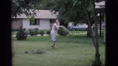 Clarkdale Arizona (1966): Woman Grabs A Large Pile Of Leave Or Lawn Clipping And