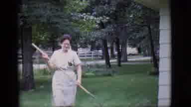Clarkdale Arizona (1966): Happy Old Woman Raking The Backyard Grass During The Day