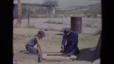 Flagstaff Arizona USA (1967): Man And Boy Sitting Building With A Red Barrel On