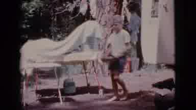 Cottonwood Arizona (1968): A Young Blond Boy Carries A Pan Across The Yard