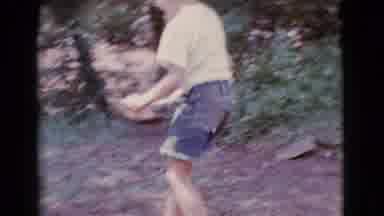 Cottonwood Arizona (1968): Boy Wearing White Shirt Sets Bowl Of Food On Wooden