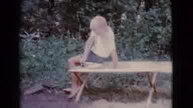 Cottonwood Arizona (1968): A Boy Sitting Down On A Wooden Table Outside Near Some