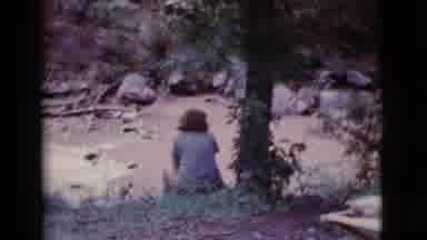 Cottonwood Arizona (1968): Woman Sits On Embankment At A Beach And A Man Walks