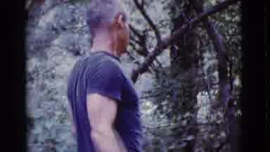 Cottonwood Arizona (1968): Man Wearing Blue Shirt Looks At Green Trees On A Clear