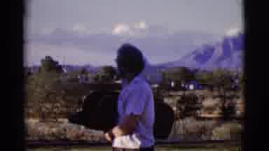Cottonwood Arizona (1968): A Lady Looking At A Person's Spraying Water On A