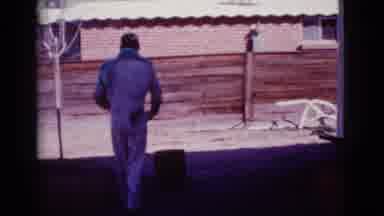 Cottonwood Arizona (1968): Man Wearing White Jumpsuit Walks To Red Barrel On A