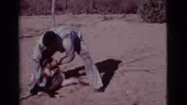 Cottonwood Arizona (1968): Man And German Shepherd Dog Play Together In The Dirt