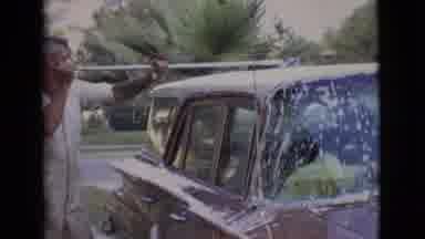 San Diego County California (1968): Man In White Coveralls Washes Car In Driveway