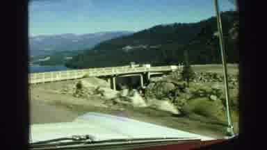 Vancouver Bc Canada (1968): A Car Driving On A Road About To Go Around A Bridge
