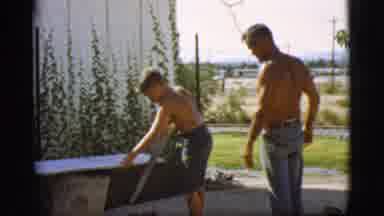 Cottonwood Arizona-1968: Shirtless Boy Cuts Board While Man Supervises