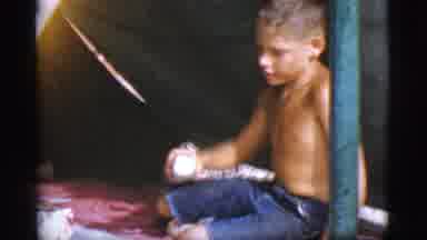 Cottonwood Arizona (1968): Boy In A Tent Screws The Lid Onto A Jar Facing The