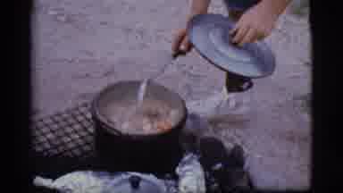 Cottonwood Arizona (1968): A Boy Checks A Pot Of Stew Cooking On A Campfire And