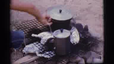 Cottonwood Arizona (1968): Person Checks The Food Wrapped In Foil Cooking On The