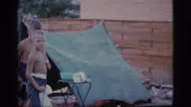 Cottonwood Arizona (1968): Two Shirtless Boys Stand Next To A Tent On A Windy Day