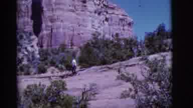 Arizona USA (1968): Woman Wearing Blue Pants Walks Down Rocky Path On A Bright