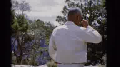 Arizona USA (1968): A Man In White Shirt And Khakis Holds His Hand Up To His Face