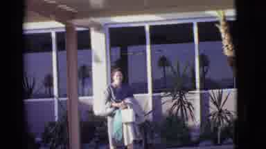 Arizona USA (1968): Woman Carrying Many Shopping Bags Waits Outside Airport Where