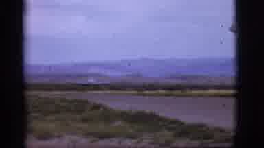 Flagstaff Arizona (1968): A Small Blue Plane Taking Off On A Runway During The Day
