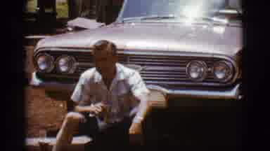 Flagstaff Arizona (1968): Man Sitting Down In Front Of His Car While He Eats