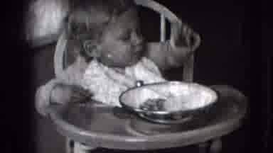 New Hampshire USA (1942): Small Child Sitting In A High Chair Grabbing Food Off