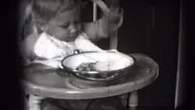 New Hampshire USA (1942): Toddler Sitting In High Chair Eating Using Pincer Grasp
