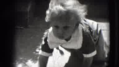 New Hampshire USA (1942): Baby Wearing Grey Overalls Crawls On Sidewalk On A Sunny