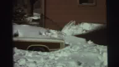 East Lansing Michigan (1972): A Person Shoveling Snow Off The Garage With Cars