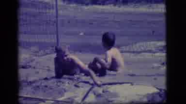 Ely Nevada (1968): Two Boys Playing In Their Swimsuits In A Large Mud Puddle And A