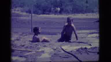 Ely Nevada (1968): Two Young Boys Laugh And Play In The Mud On A Sunny Day